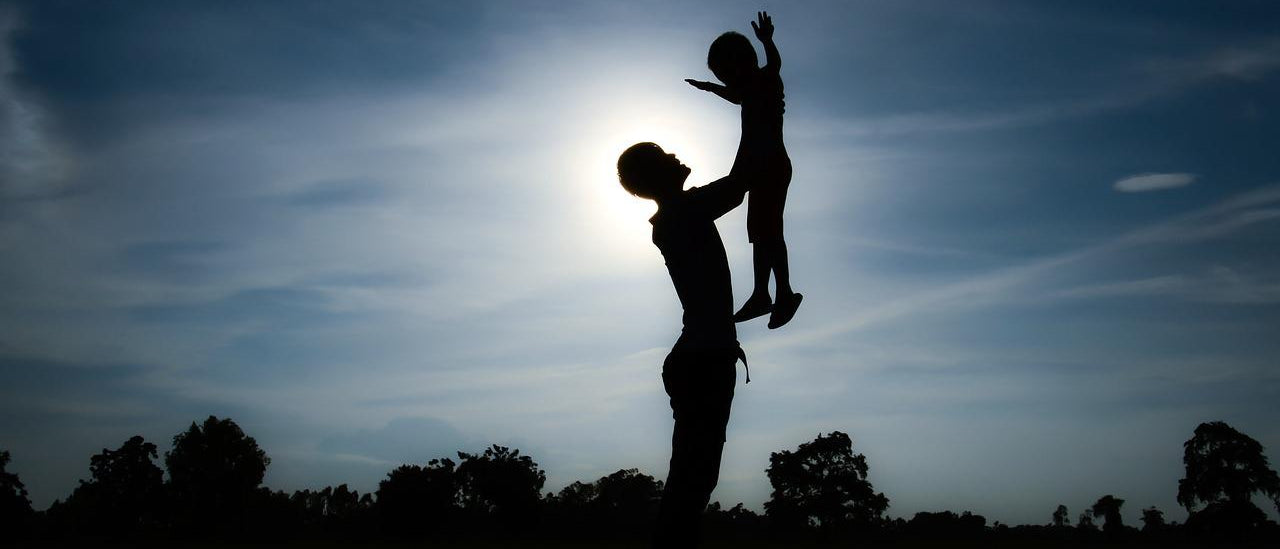 Sillouhetted Child Being Lifted Up